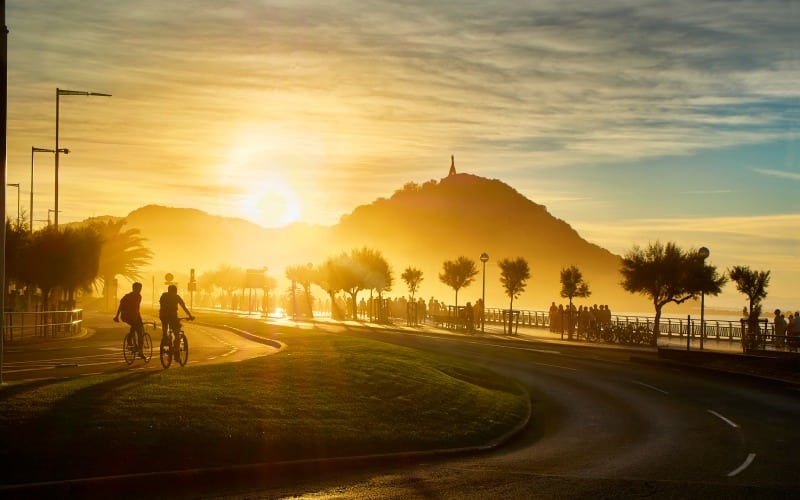 Two people riding a bike in San Sebastián.