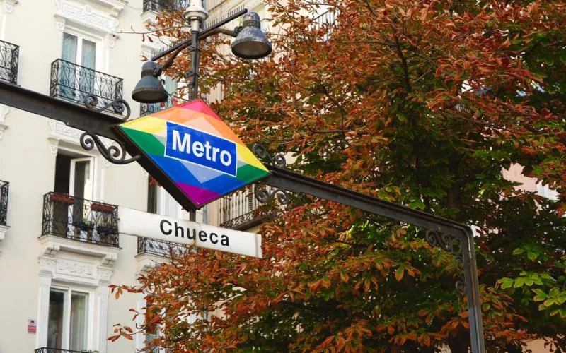 The underground station in Chueca, with the rainbow colours, and a tree in the background