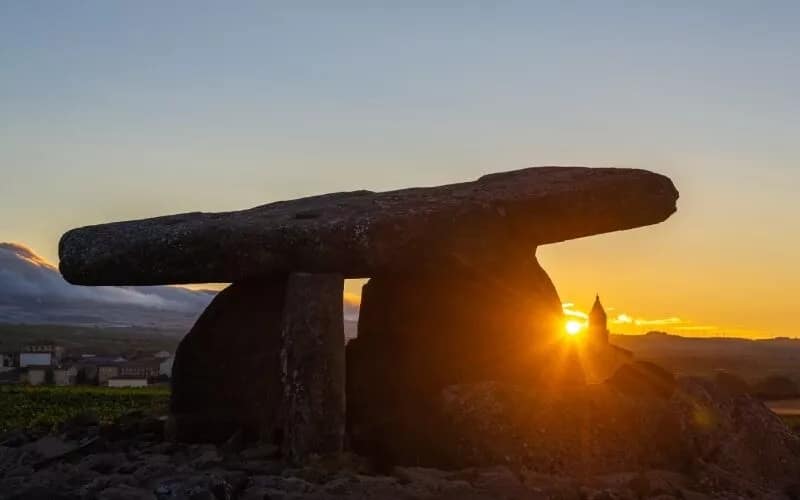 The sun setting behind a dolmen