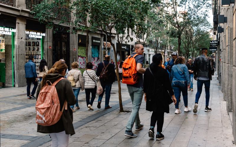 A street with shops in both sides and people walking