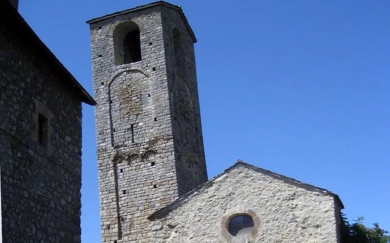 A tower among stone buildings and blue sky