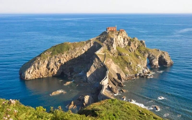 The island from above, with the blue sea and the stairs reflecting the sun
