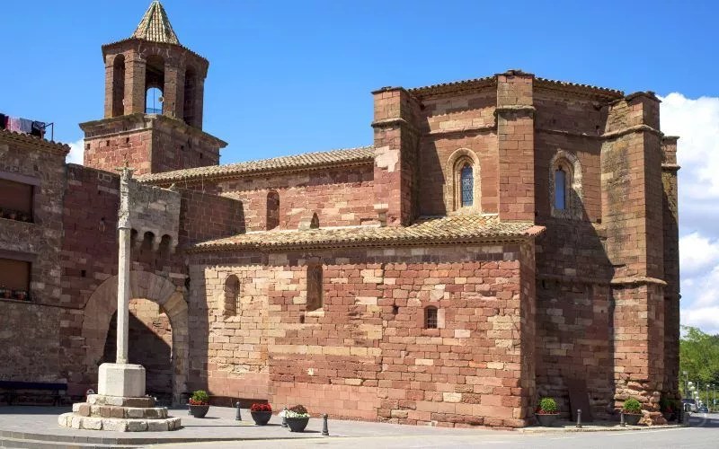 A reddish church with a bell tower