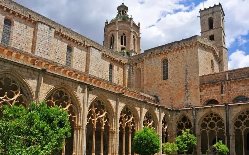 A cloister with archways and a bell tower