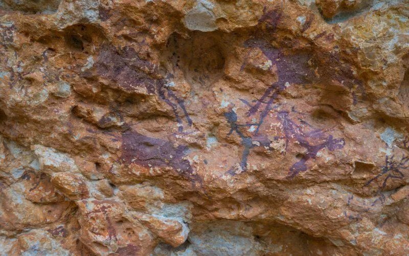 Reddish cave paintings on a rock
