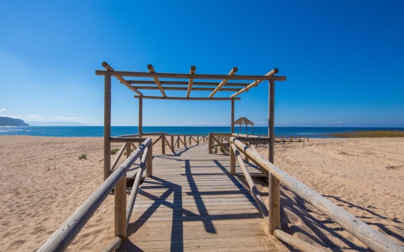 A beach with a wooden structure and a blue sky