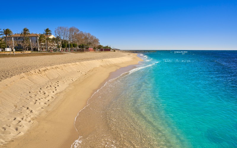 A beach with golden sand and turquoise waters