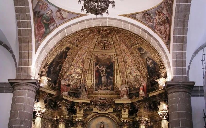 A dome inside a church decorated with rich paintings and sculptures