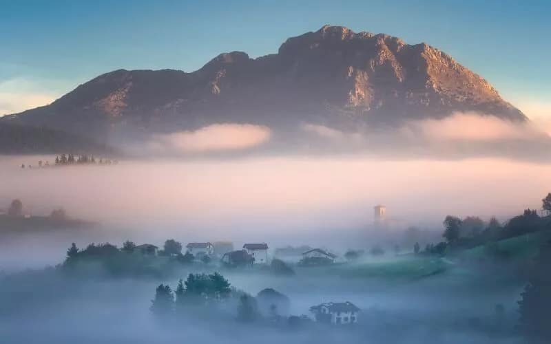 Fog in the valley, a mountain in the background