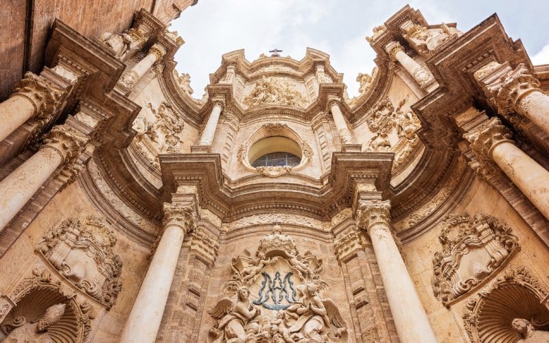 A highly decorated exterior wall of a cathedral, with sculptures and columns