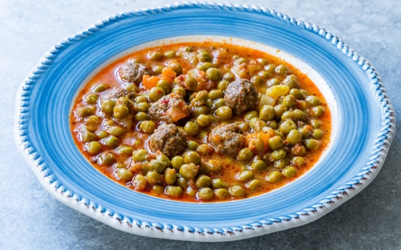 A meatball stew on a blue plate
