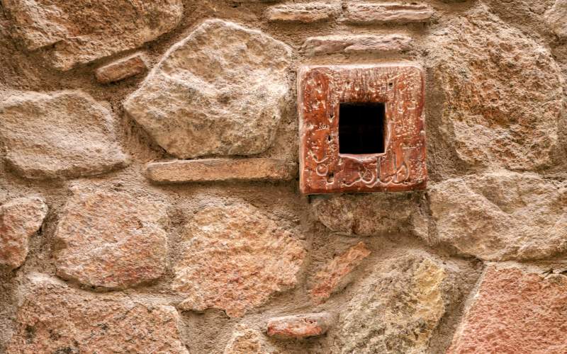 A small square whole on a stone wall