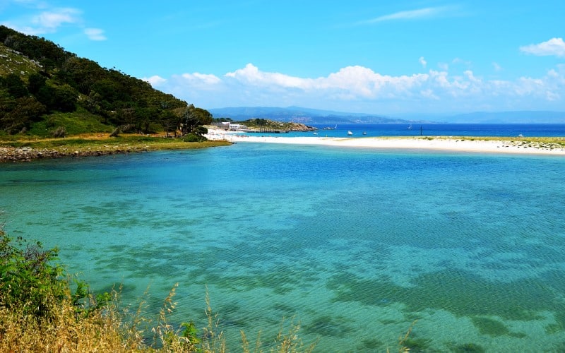 A lagoon with turquoise waters, with the beach and the sea in the background