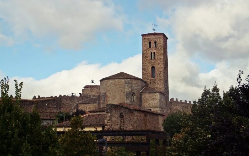 A church with a tower and trees on both sides of the picture