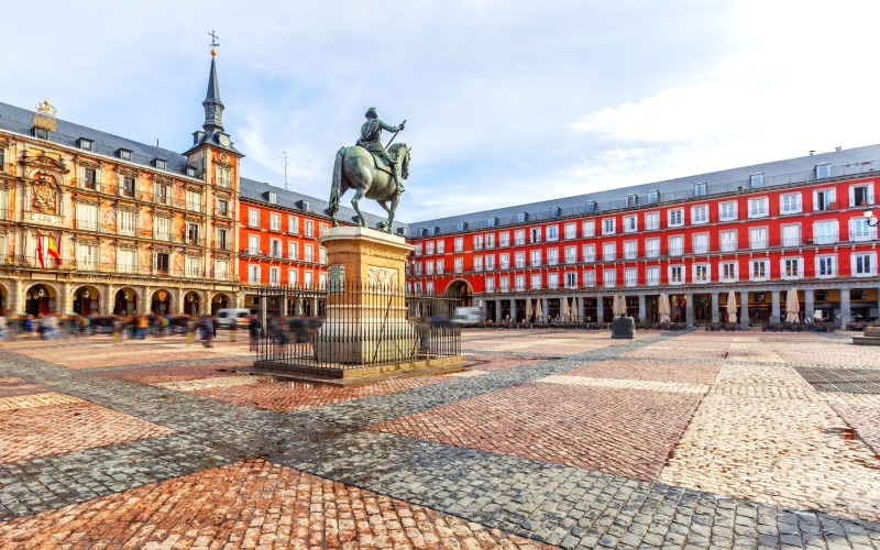 A large square with red buildings and a horse statue