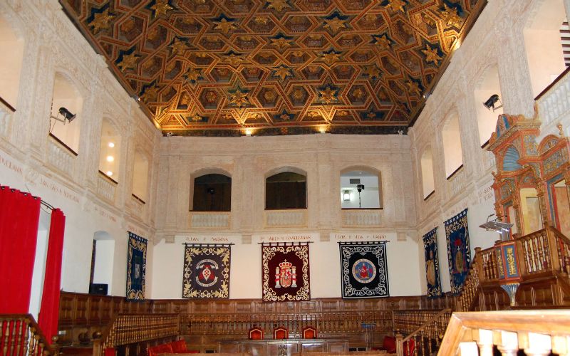 An assembly room with white walls and wooden structures 