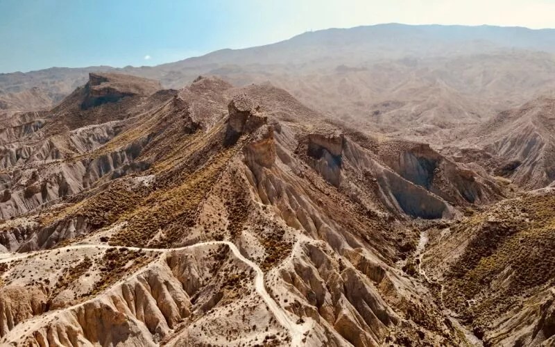 An aerial view of a desert with brown dunes