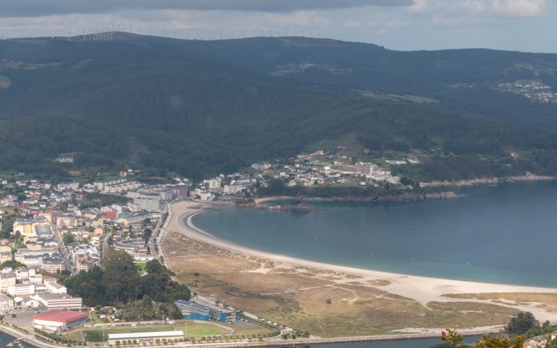 A beach and a city surrounded by mountains