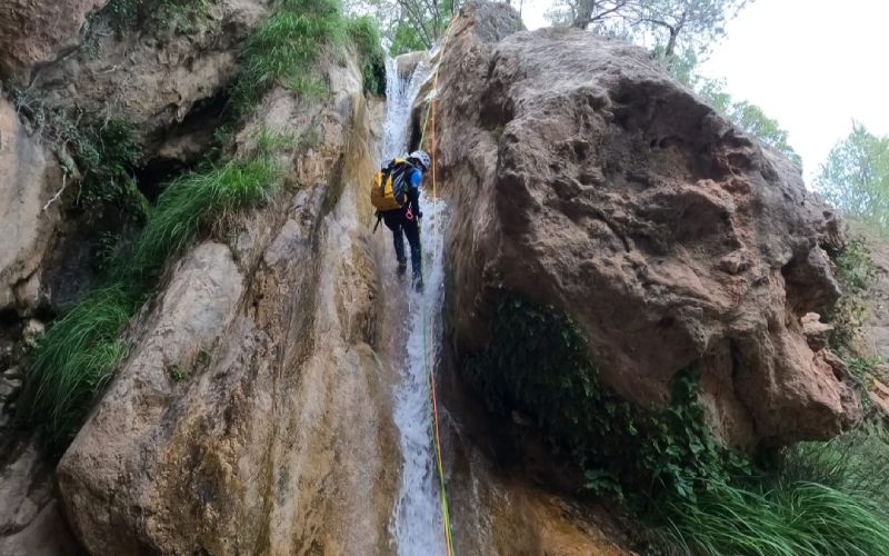 A person canyoning in a rock wall