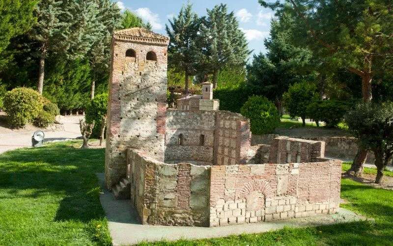 A miniature replica of a stone church in a park