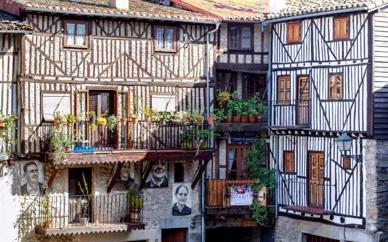 Traditional houses with balconies, plants and pictures with faces