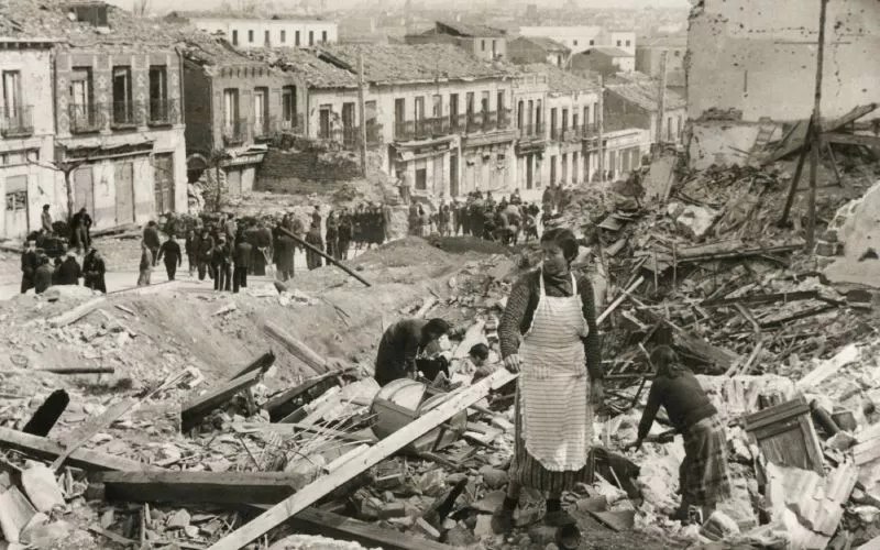 Civilians walking among ruins after a Nationalist attack during the Spanish Civil War