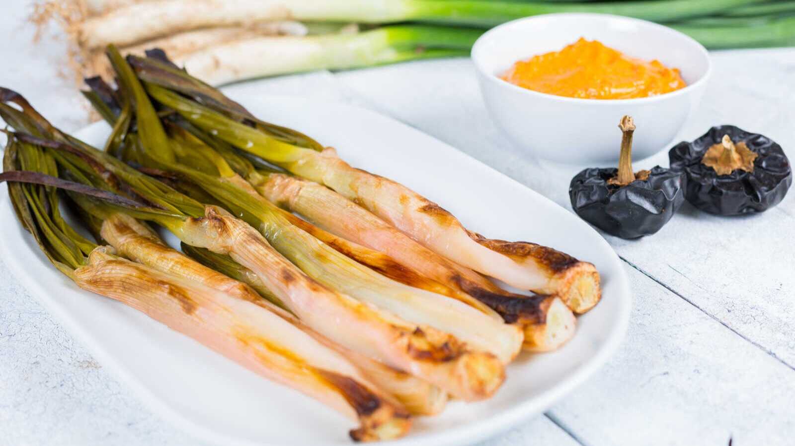 Calçots with sauce. | Shutterstock